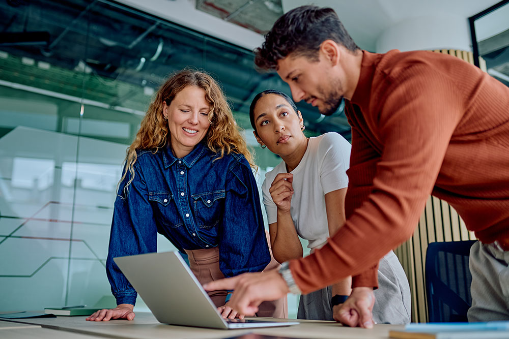 dental seo marketing team huddled around laptop