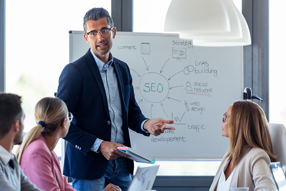 handsome dental seo specialist explaining seo concepts to his dental marketing team